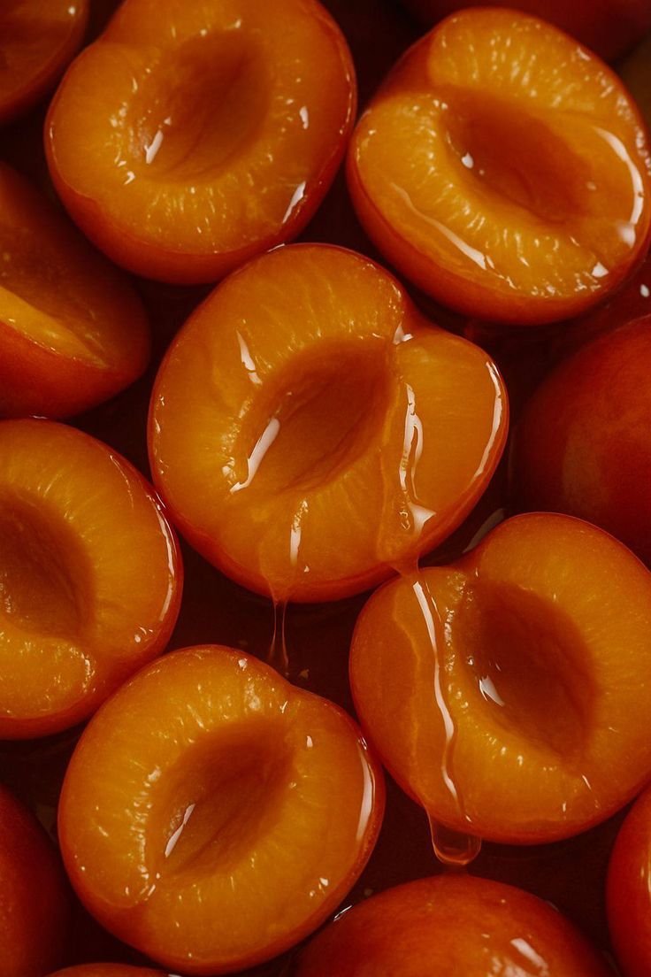 Halved peaches with orange flesh and syrupy juice inside.