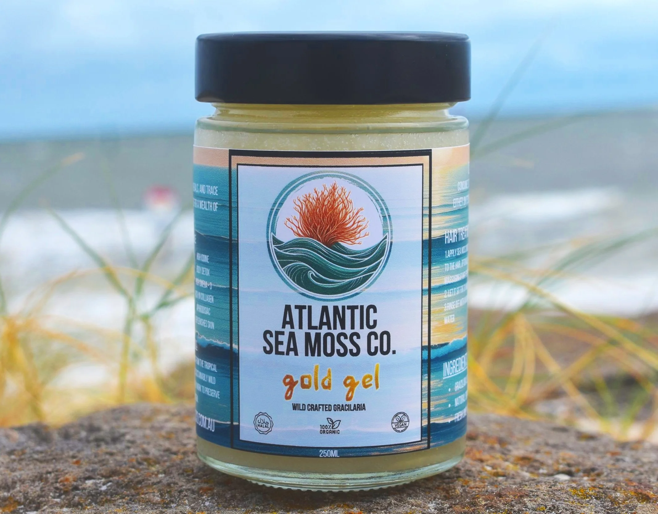 A jar of Atlantic Sea Moss Co. gold gel placed on the ground with blurred grass and soil in the background.