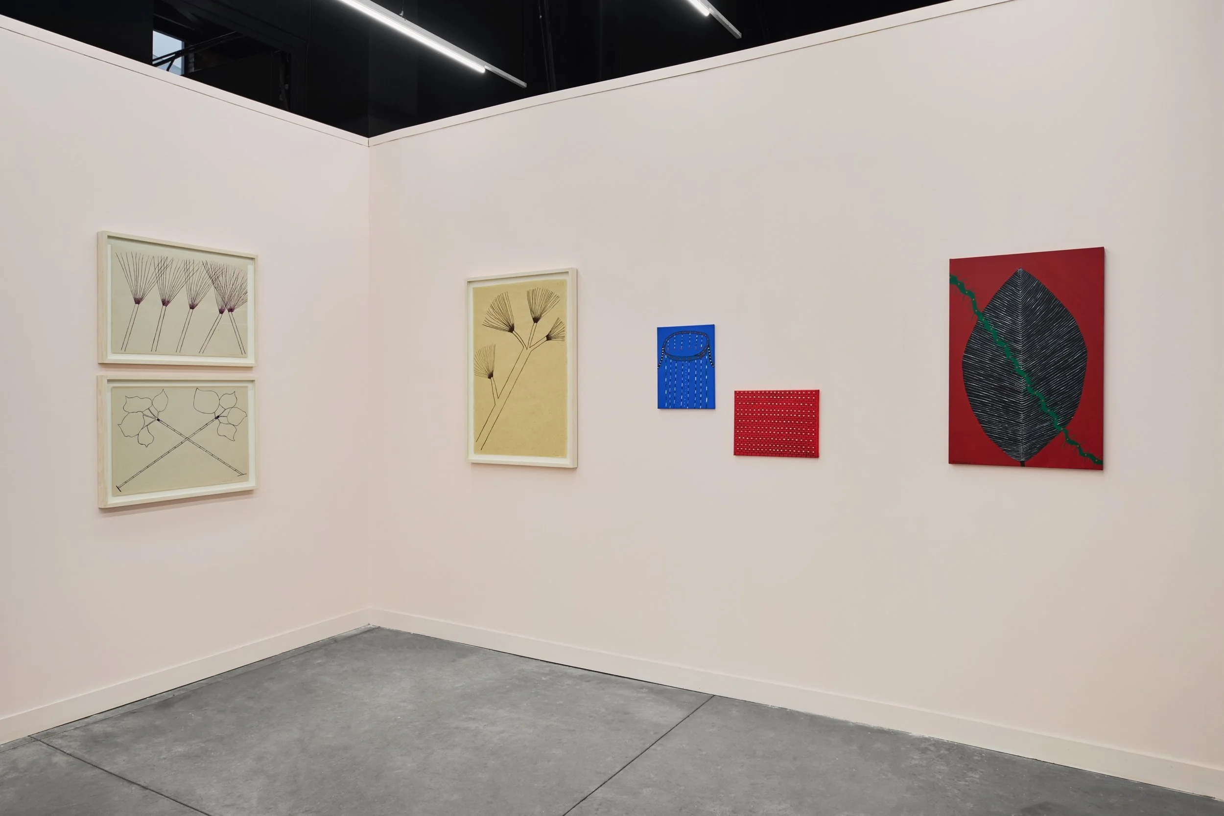 Minimalist booth display of framed botanical drawings and small abstract works arranged along pale pink walls.