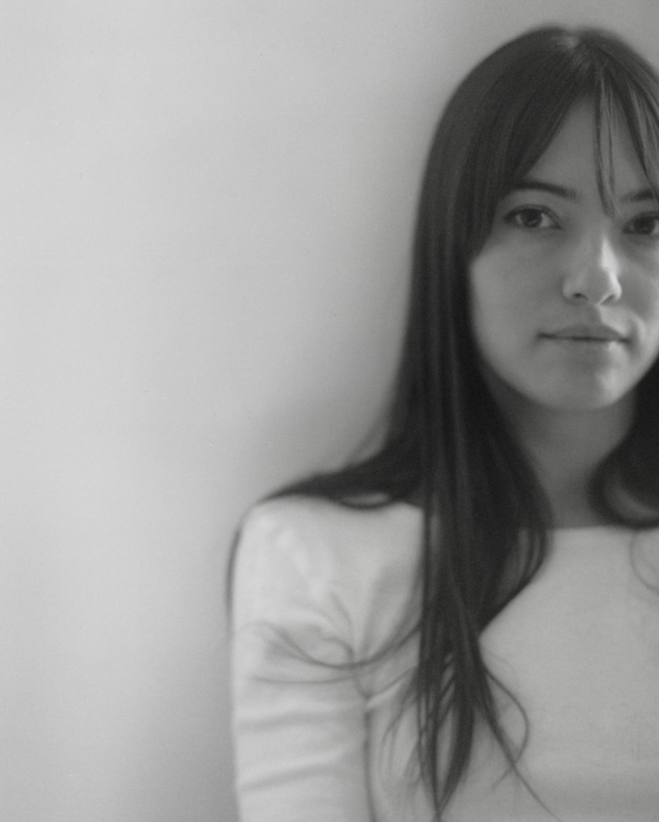 Black-and-white portrait of a woman partially cropped, gazing directly at the camera.