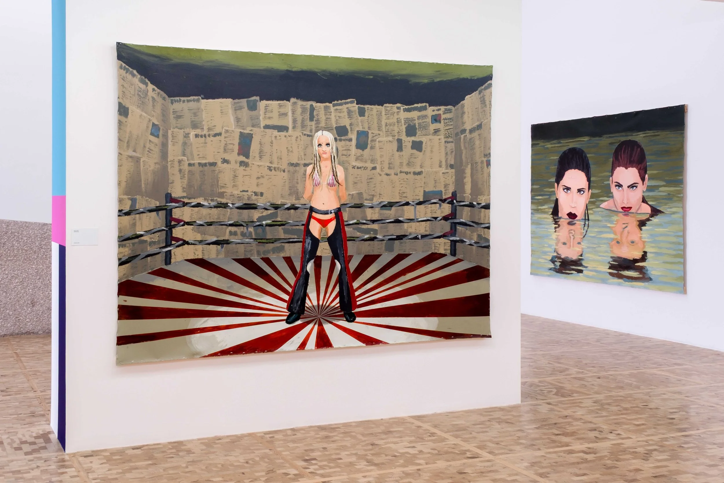 Two walls in a gallery space depict people: one features a woman in a boxing ring; the other shows two women's heads reflected in the water they stand in.