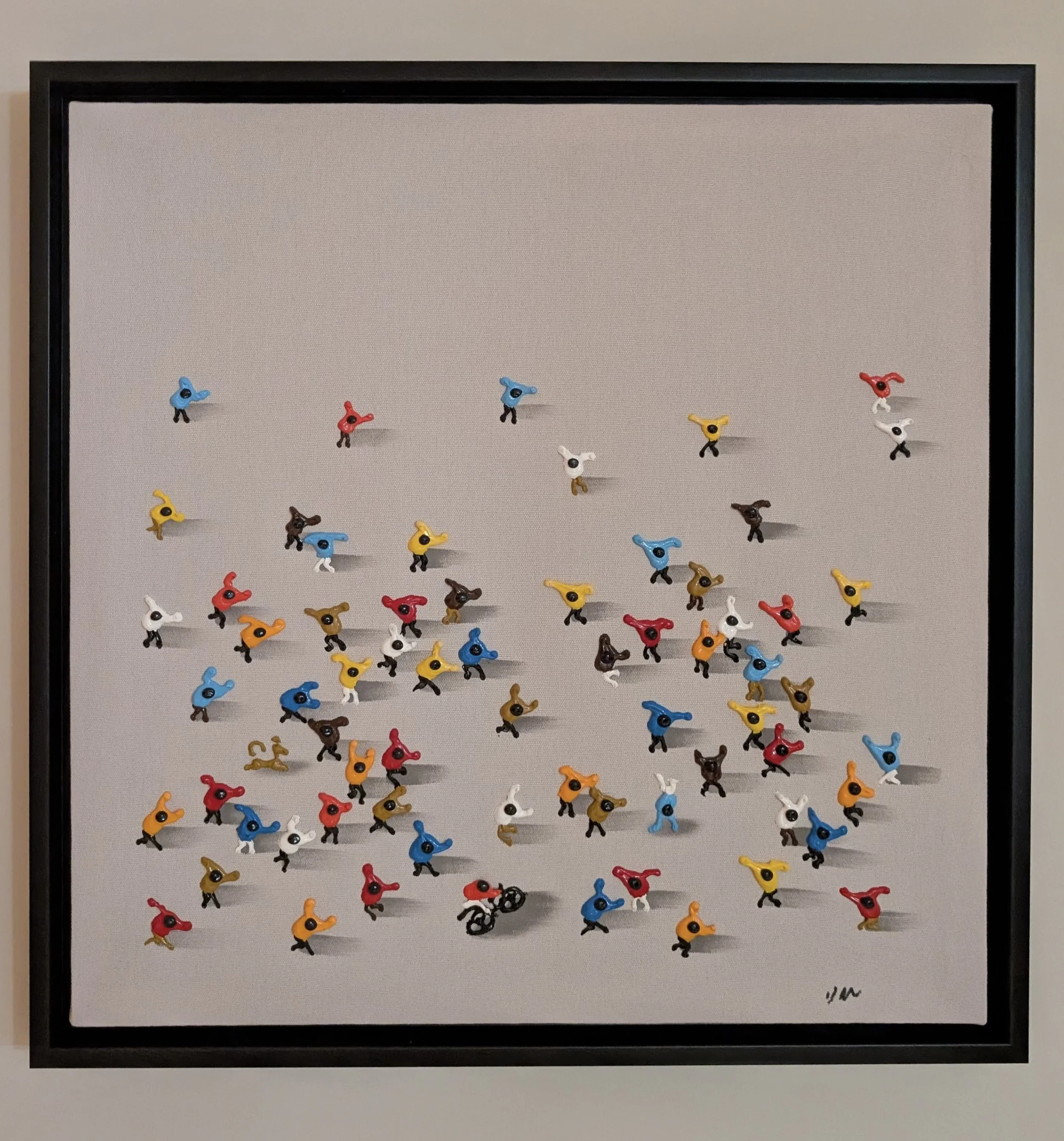 A framed artwork showing dozens of small, colorful abstract figures scattered across a light gray background.