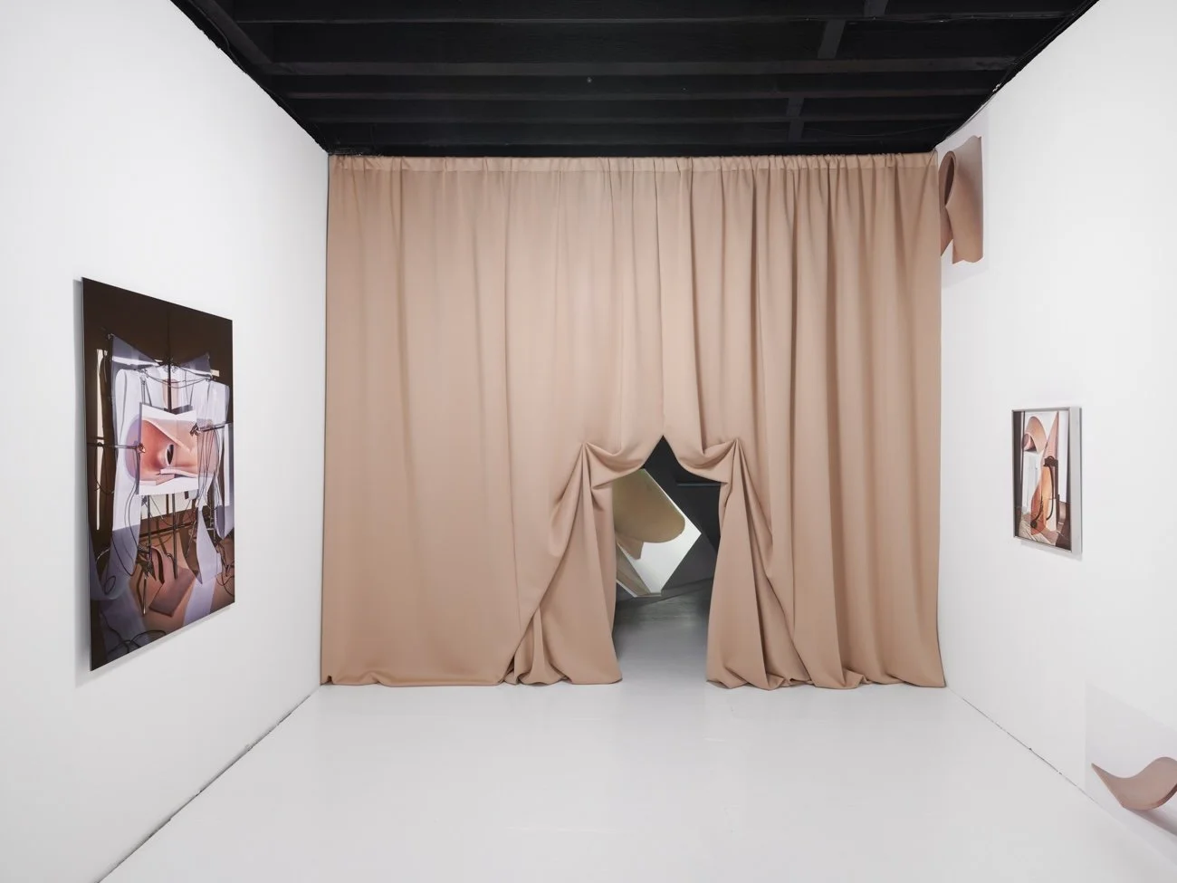Gallery installation with a large, flesh-toned curtain forming an archway entrance, flanked by two artworks.