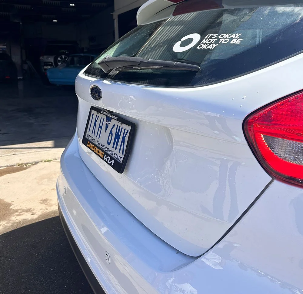 Scratch and dent repair on white hatchback car rear by Phantom Autobody