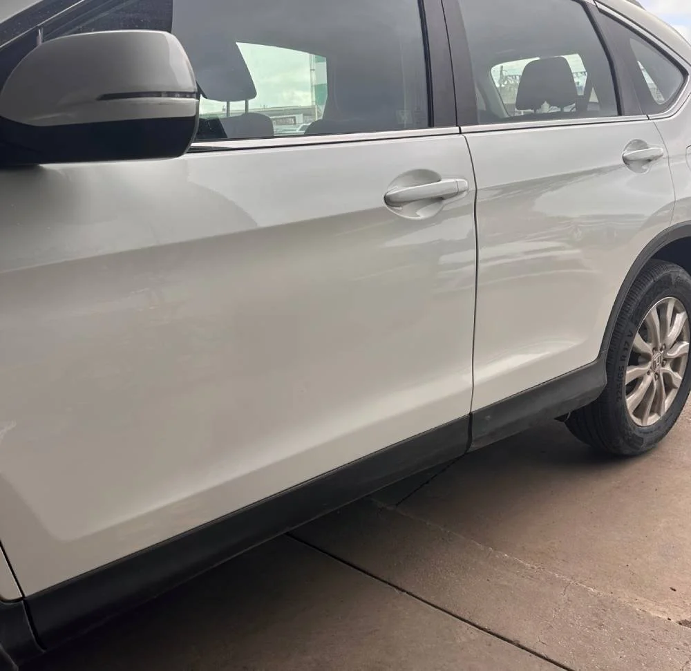 Car scratch and dent repair on body of white car by Phantom Autobody