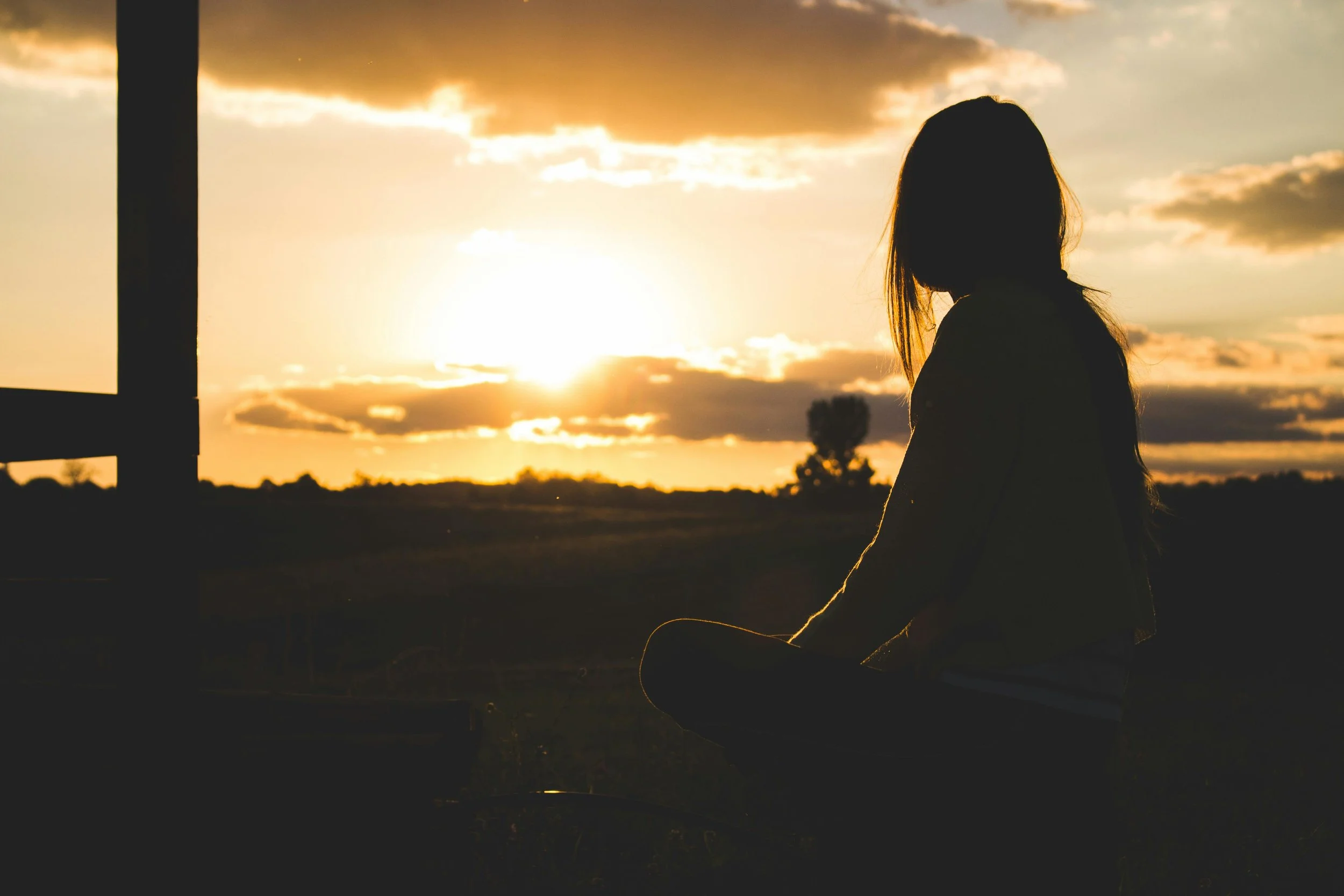 Person meditating at sunset, symbolizing reflection and integration. Photography by Vlad Bagacian - Pexels.com