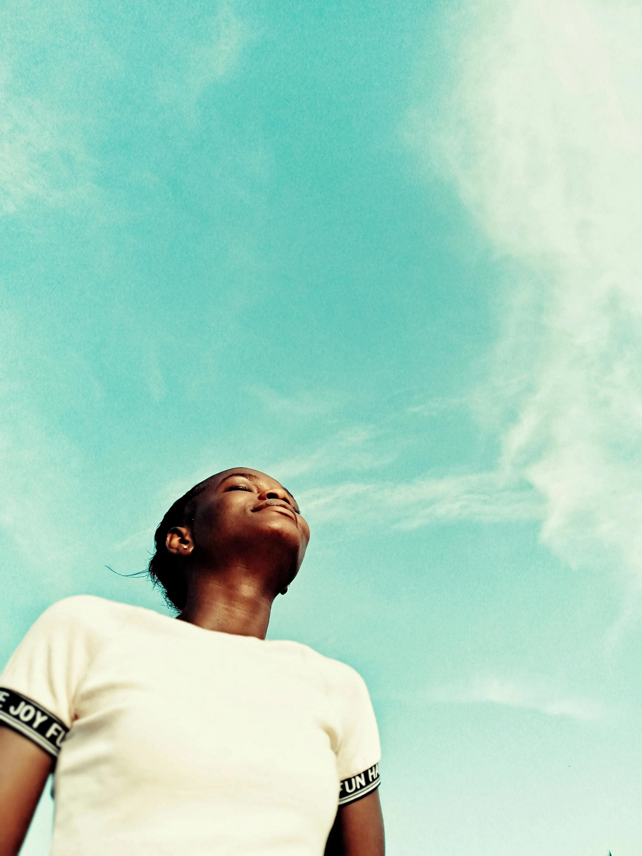 Woman gazing upwards at the sky in a moment of peaceful reflection. Photography by Melvin - Pexels.com