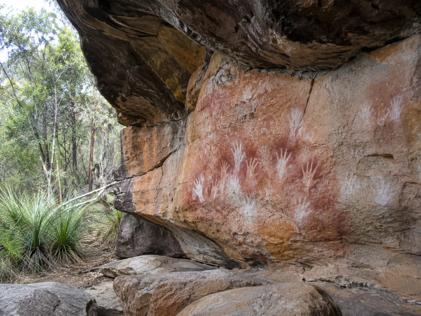 Aboriginal ochre hand stencils on a sandstone shelter wall in NSW