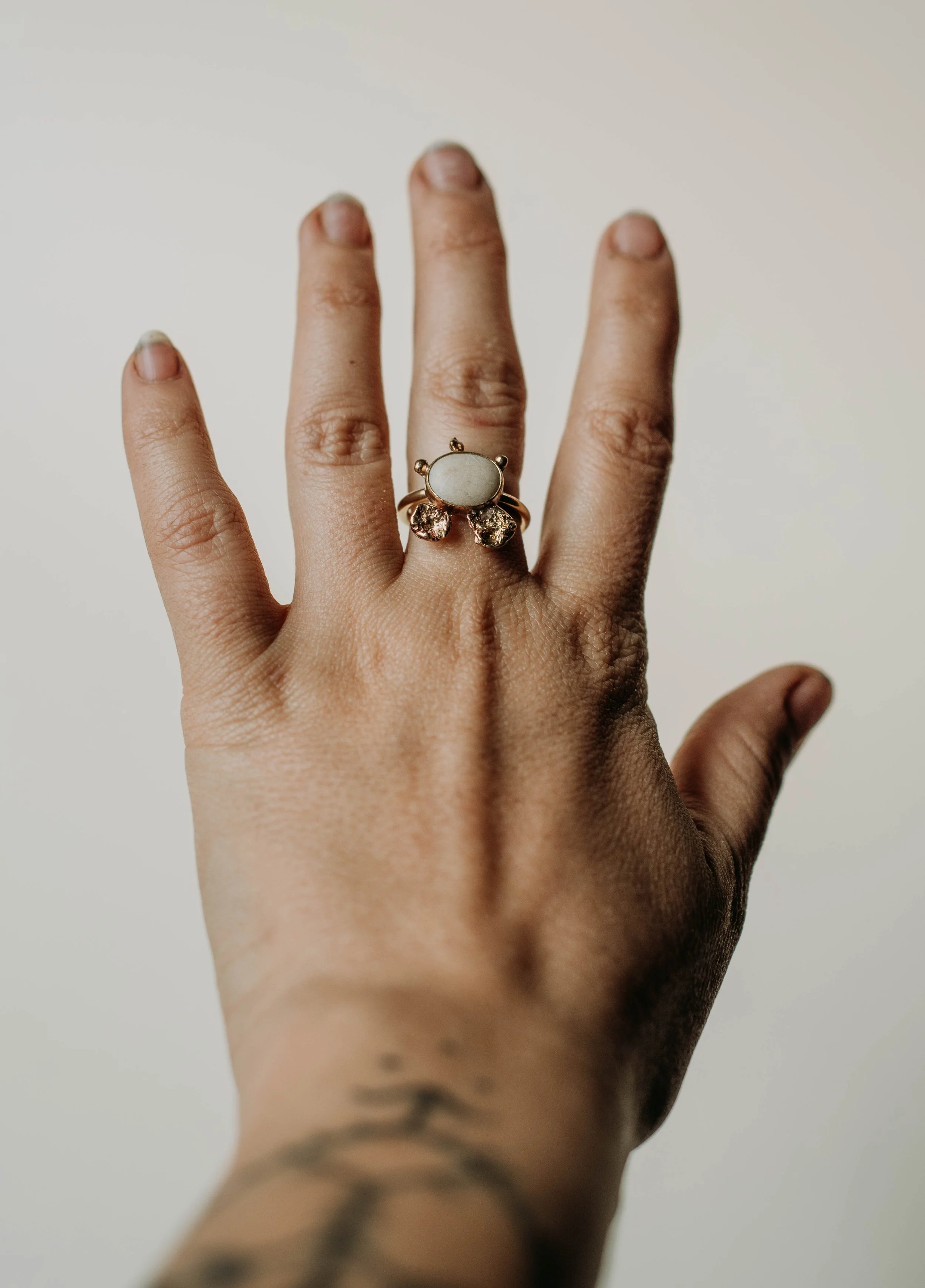 Adjustable brass ring with a small white pebble from the Lefkada coast and molten brass details, handmade one-of-a-kind jewelry
