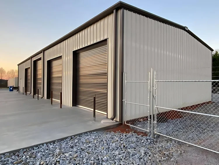 Tan multi-bay steel garage with dark roll-up doors