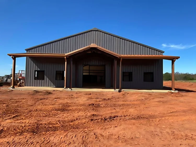 Front of a dark gray barndominium with a gable porch