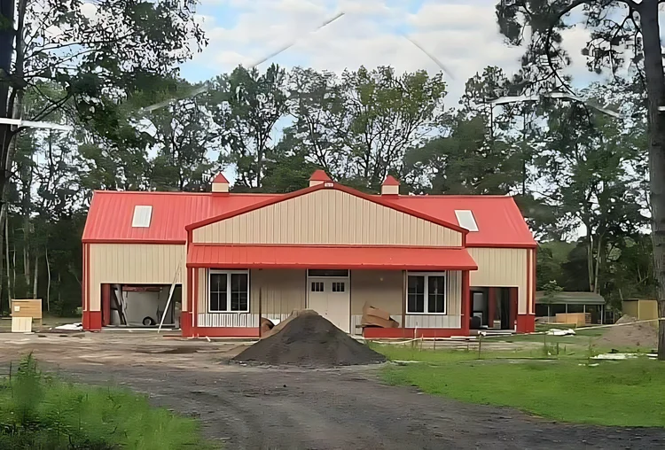 Front porch of a tan steel home with a red roof
