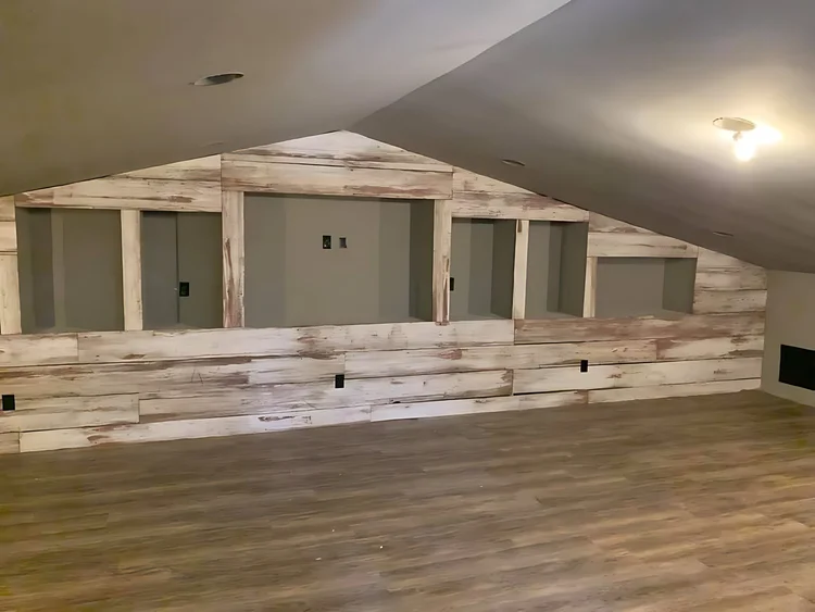 Finished loft with reclaimed-wood wall inside a steel building