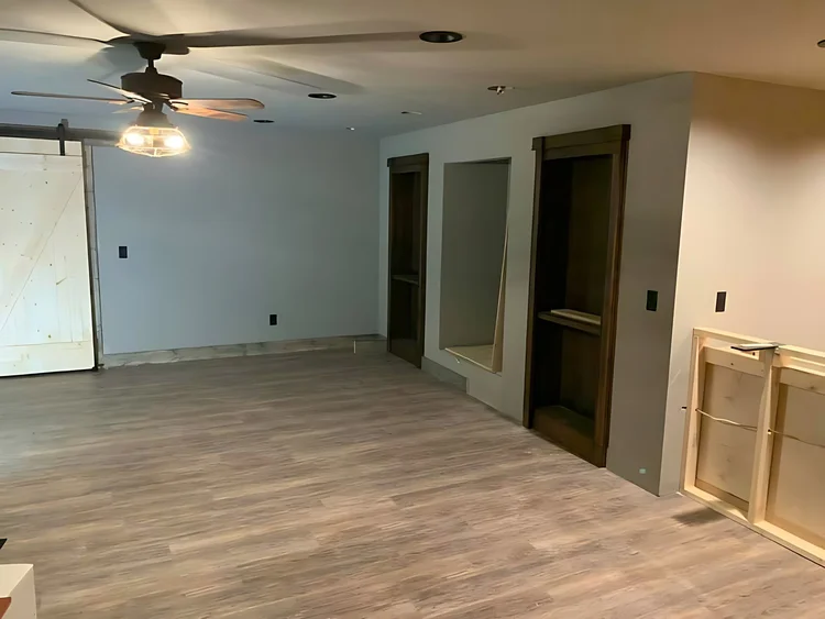 Finished living area with wood-look floors and trimmed doors
