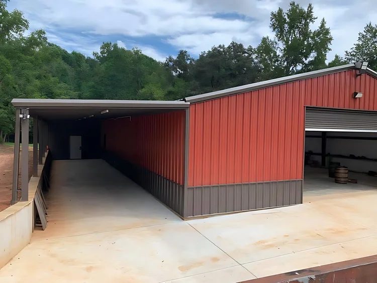 Red steel building with a long covered lean-to