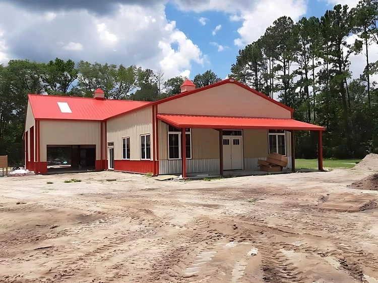 Tan and red barndominium with porch