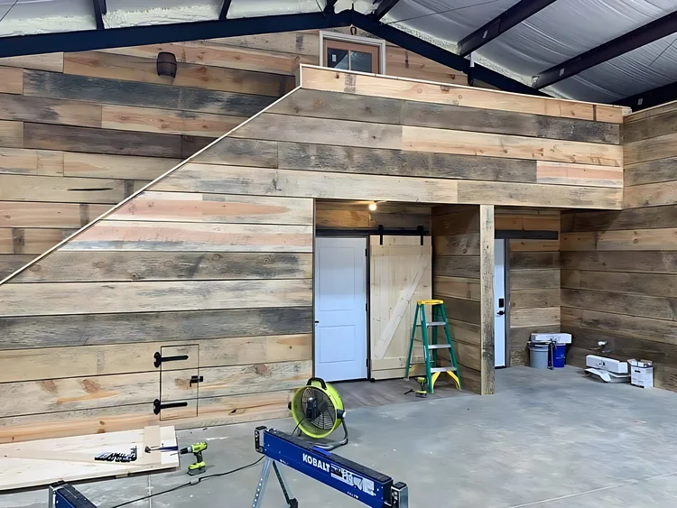 Reclaimed-wood accent wall inside a steel shop
