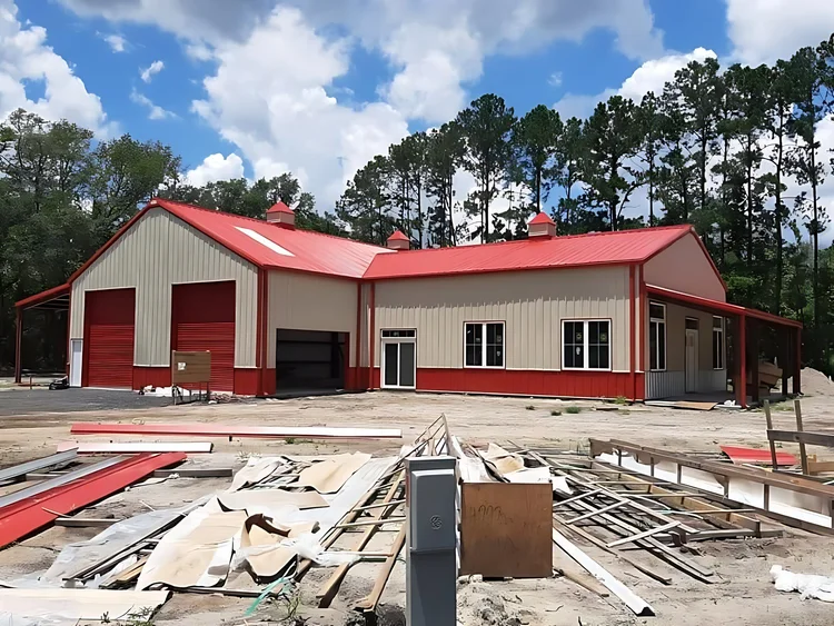 Tan and red barndominium with shop doors during finish work