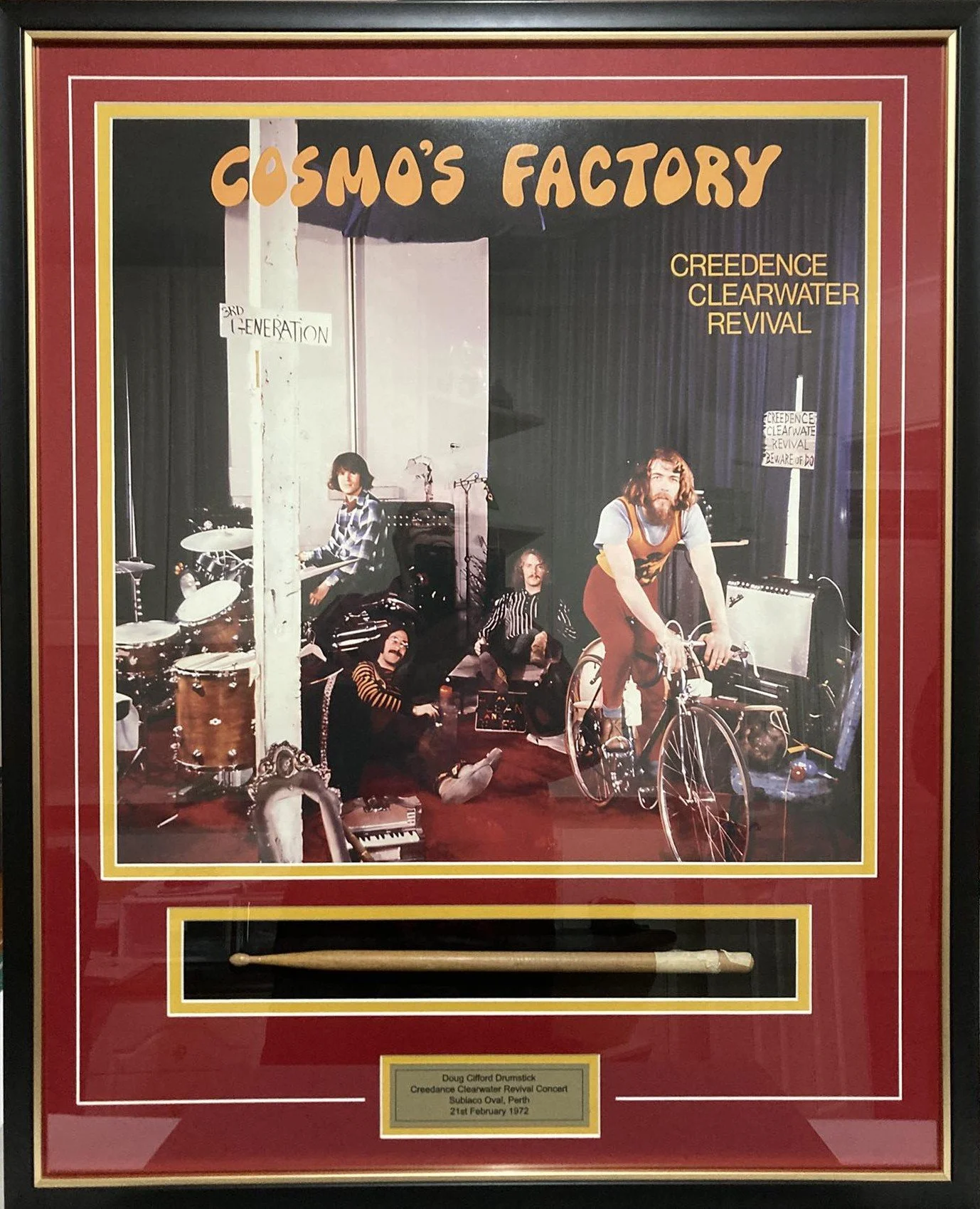 Photograph of the band Cosmo's Factory performing at the Creedence Clearwater Revival concert in Subiaco Oval, Perth, on February 21, 1972, with band members, musical instruments, and a drumstick display.