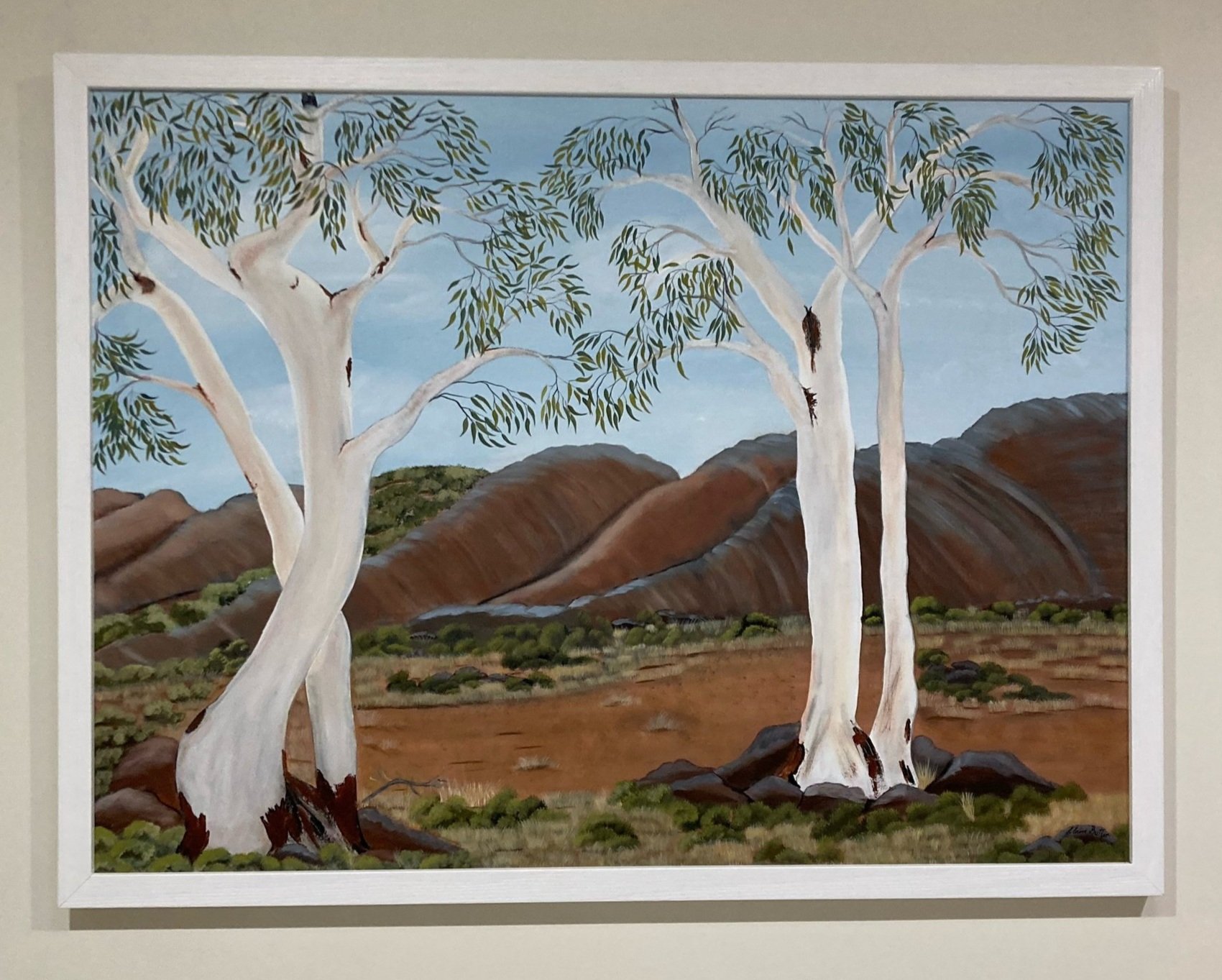 Painting of three white-barked trees with green leaves, set against a mountainous landscape with a partly cloudy sky.
