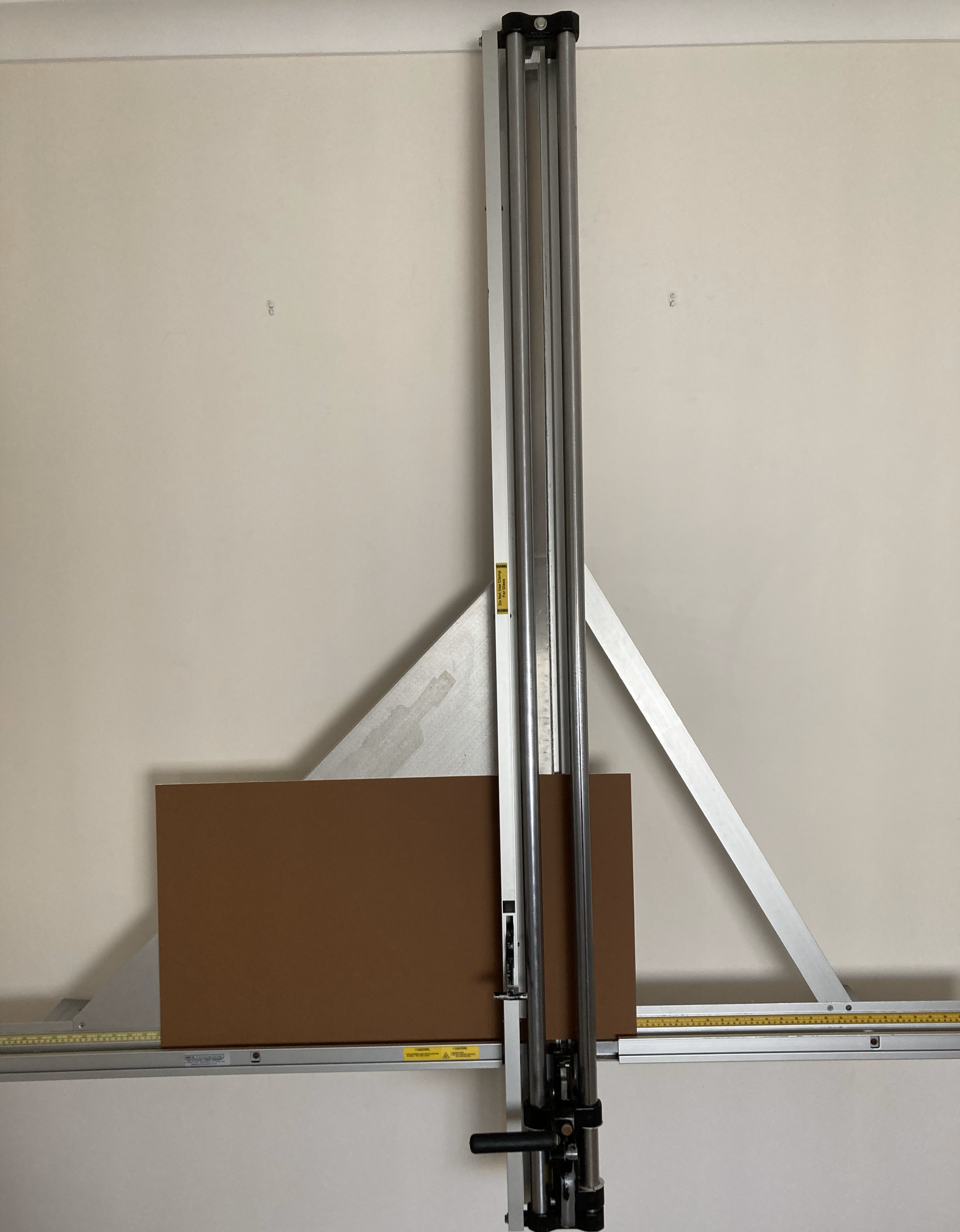 Mat board and glass cutter against a white wall.