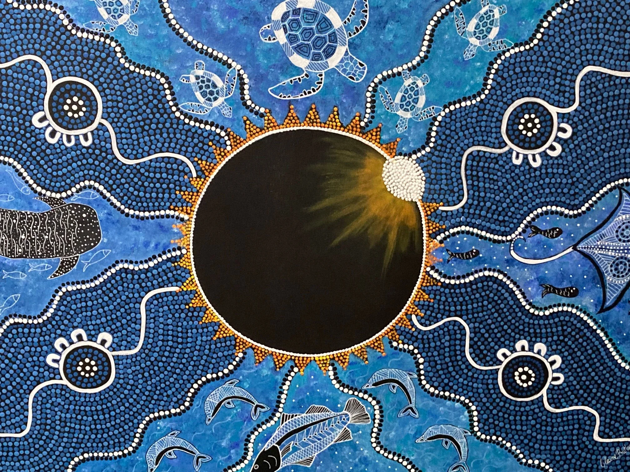 A painting of the solar eclipse with surrounding ocean creatures such as fish, turtles, a shark, and jellyfish, depicted in a vibrant, dot-patterned style with a blue background.
