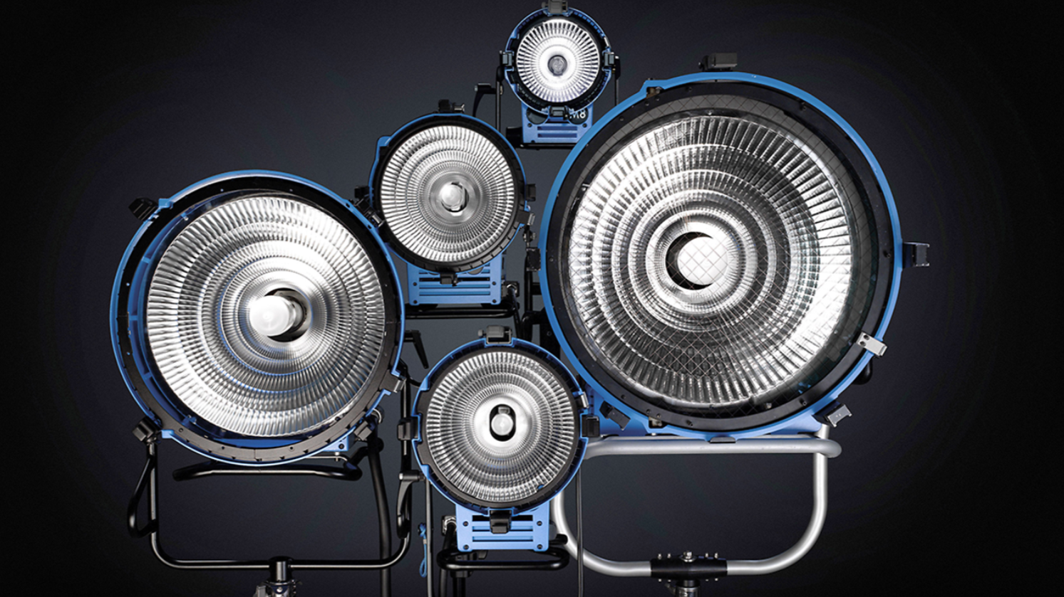 A set of professional studio stage lights with multiple circular reflectors, mounted on black and silver stands, against a dark background.

18KW Arri Max / M40 Arri / M18 Arri