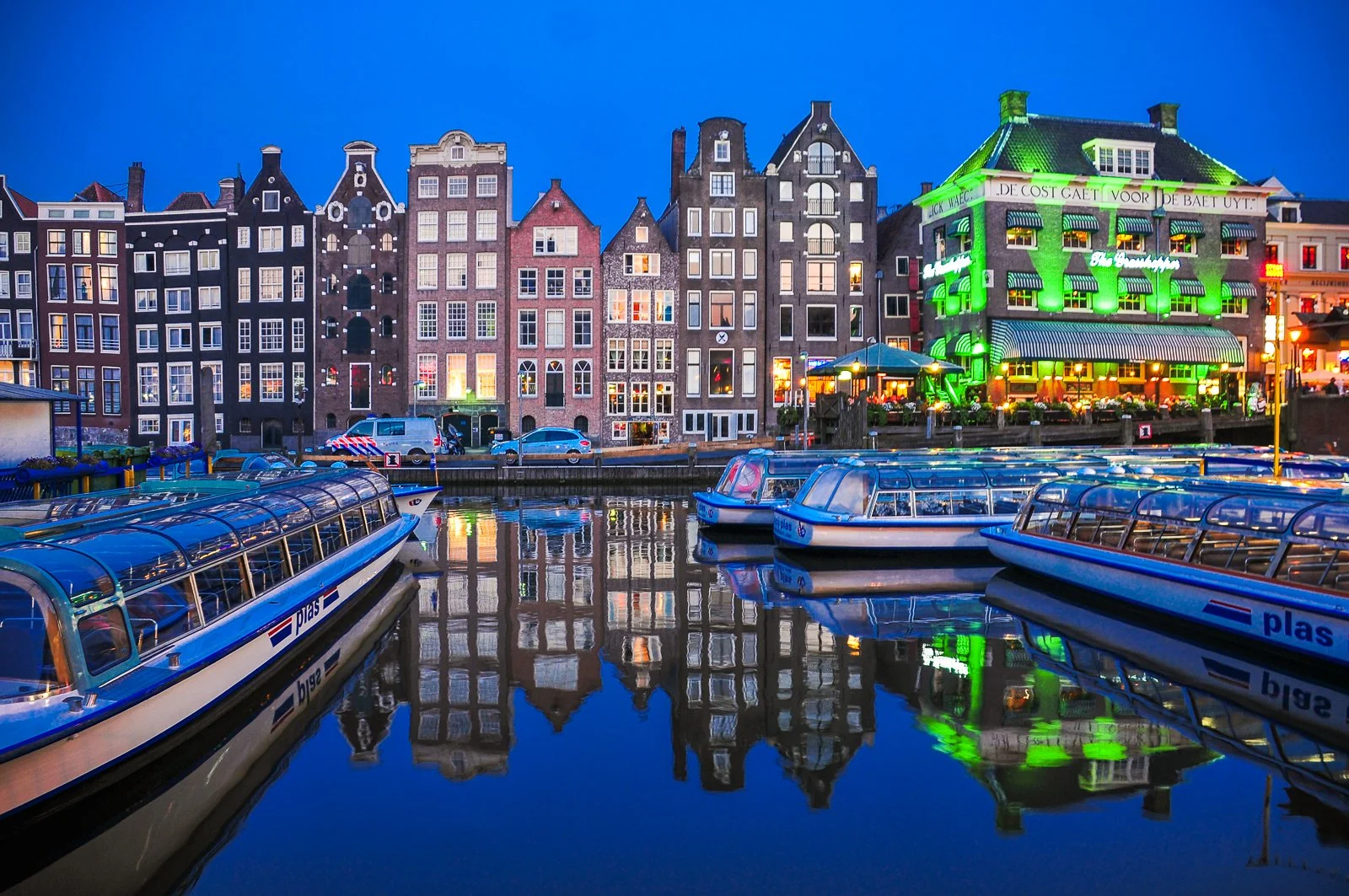 Buildings in Amsterdam reflected in the canal at twilight.