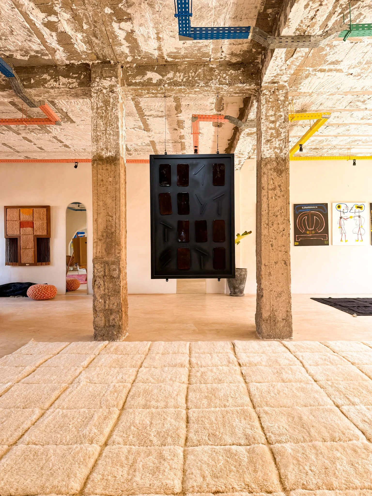 Studio shot showing rugs and sculptural pieces.
