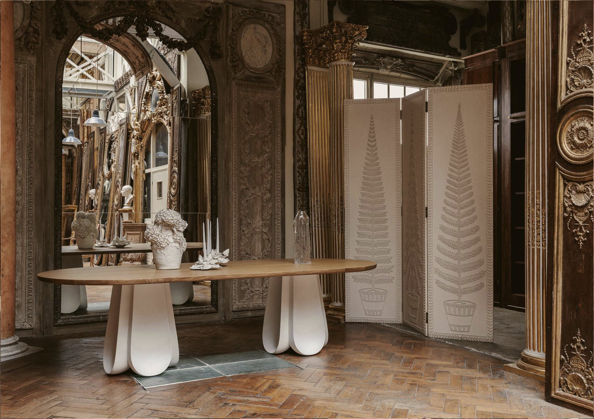 Contemporary collectible furniture staged within historic boiseries interiors at Féau Boiseries Paris
