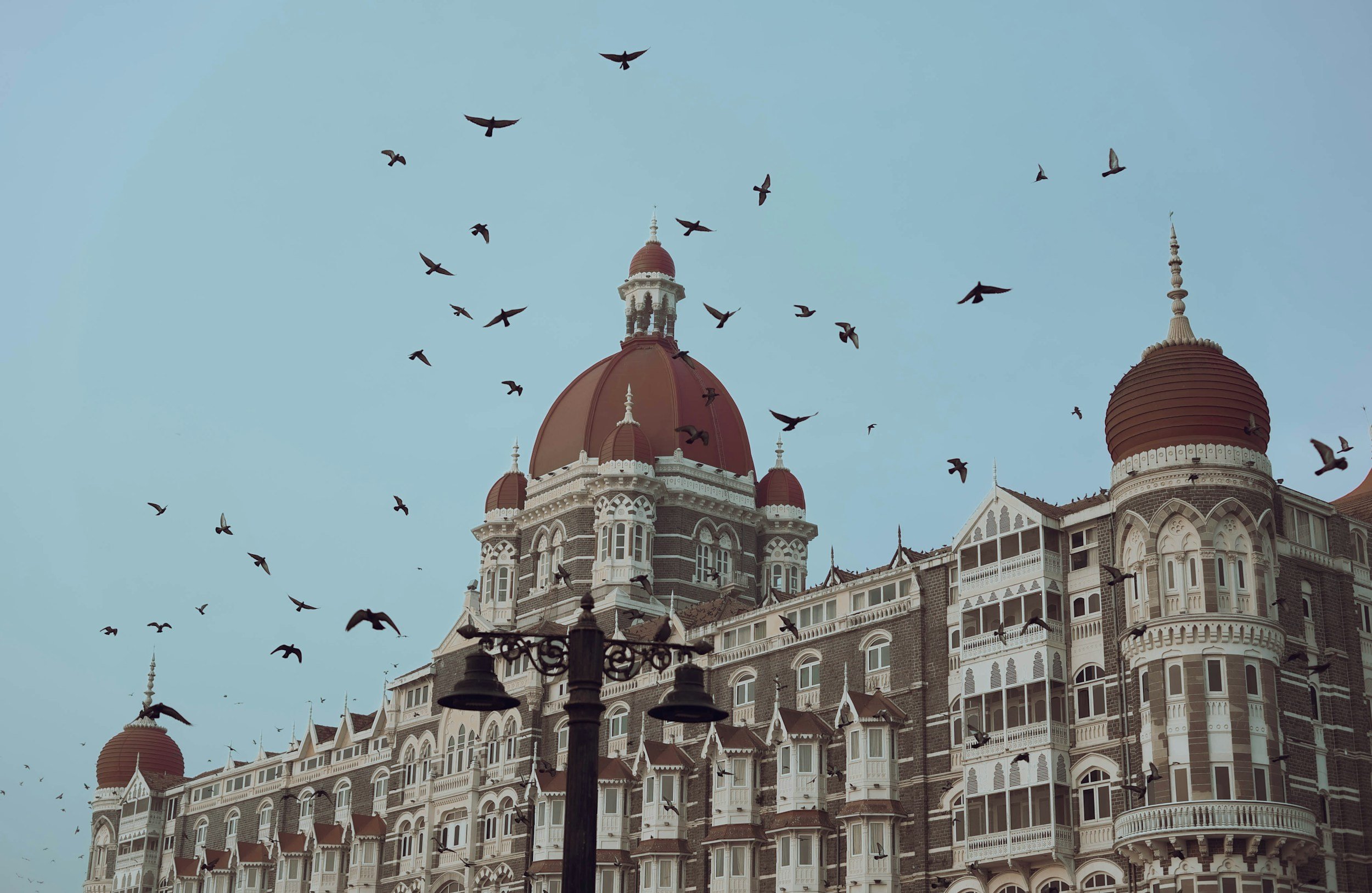 Architectural and interior details of The Taj Mahal Palace hotel overlooking Mumbai's waterfront.