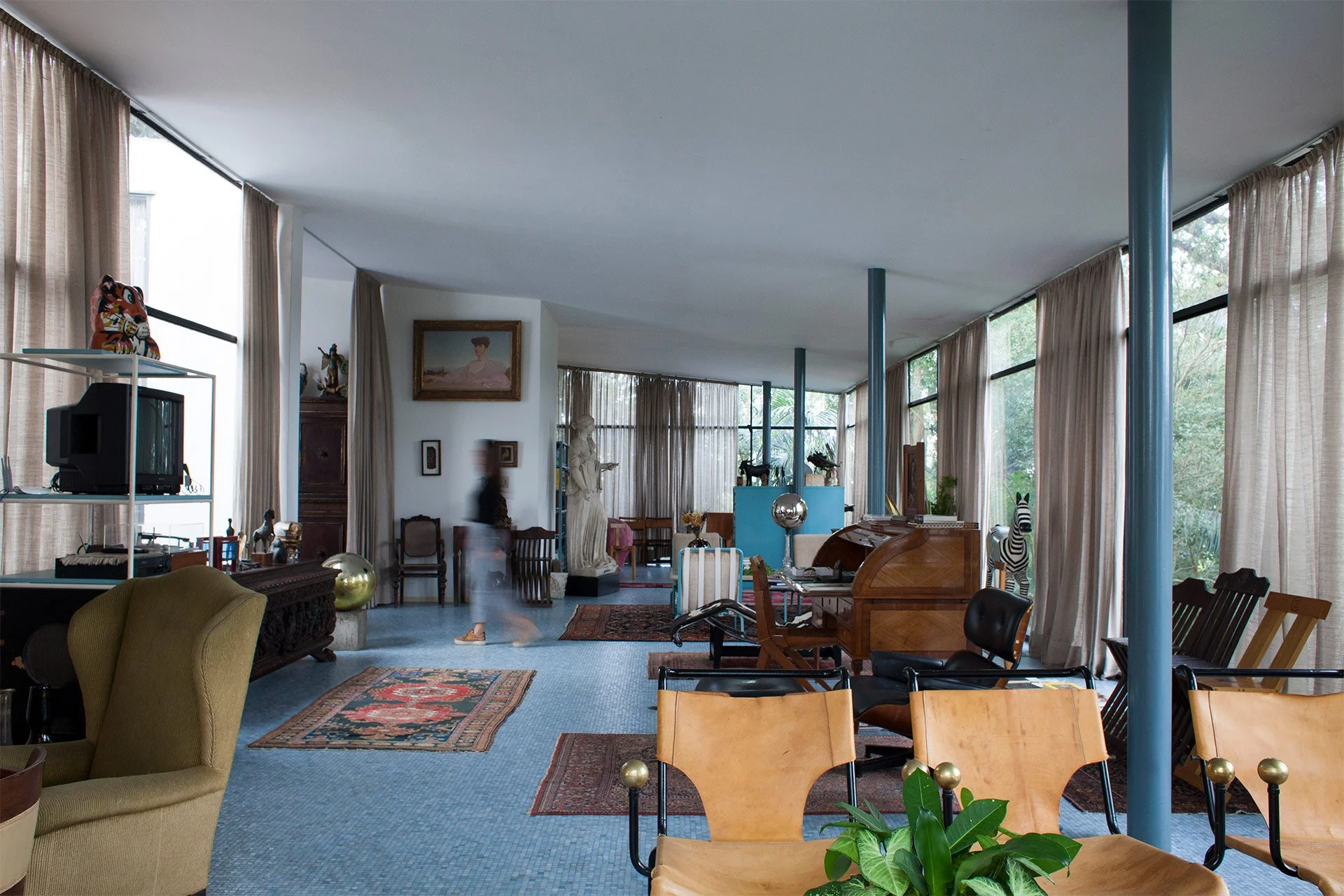 Lina Bo Bardi's Casa de Vidro surrounded by lush greenery in São Paulo.