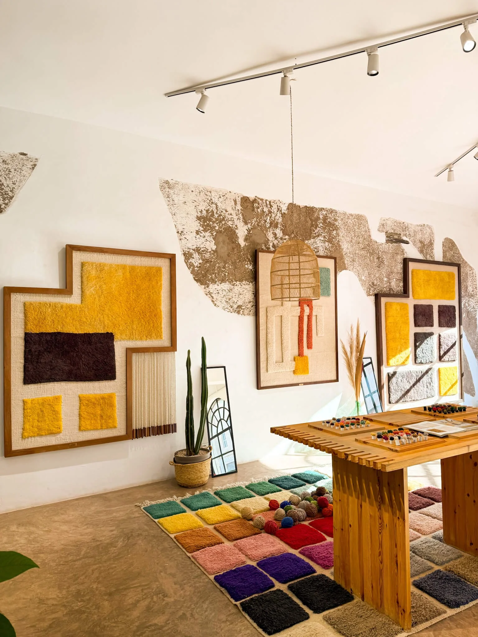 Studio shot showing rugs, sketches and sculptural pieces.