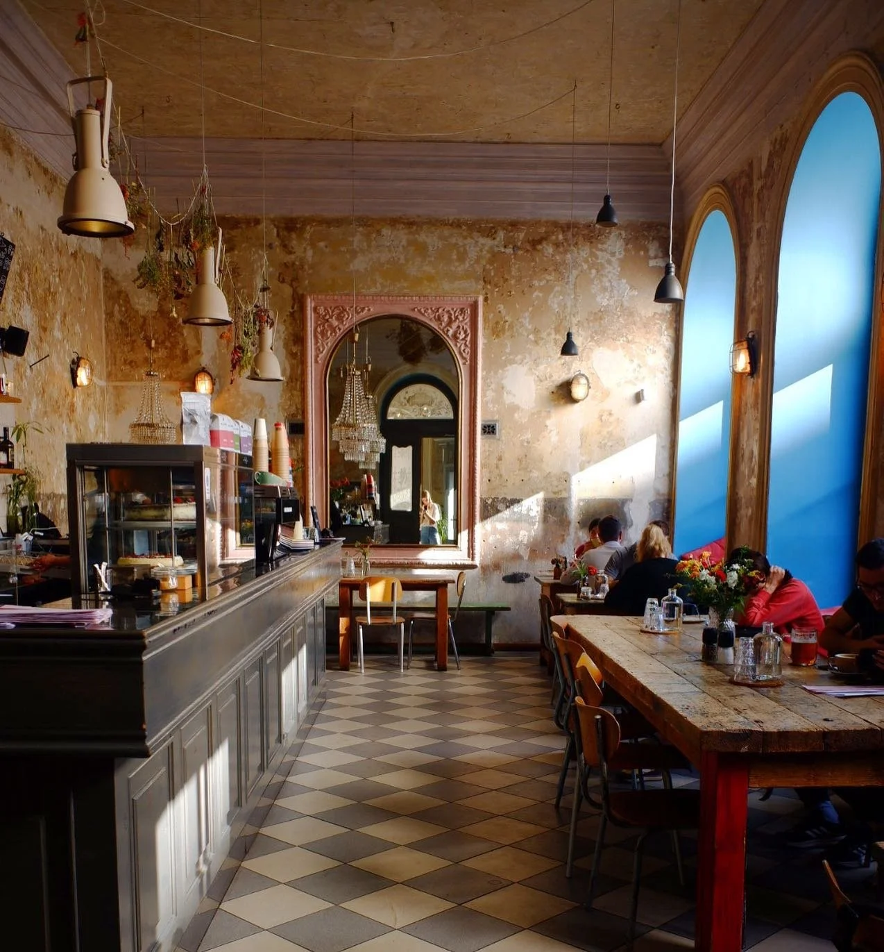 Café Letka interior in Prague featuring a peeling pink wall and large mirror