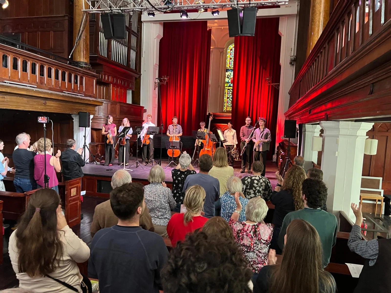 An audience watching a live musical performance in the Triskel Arts Centre.