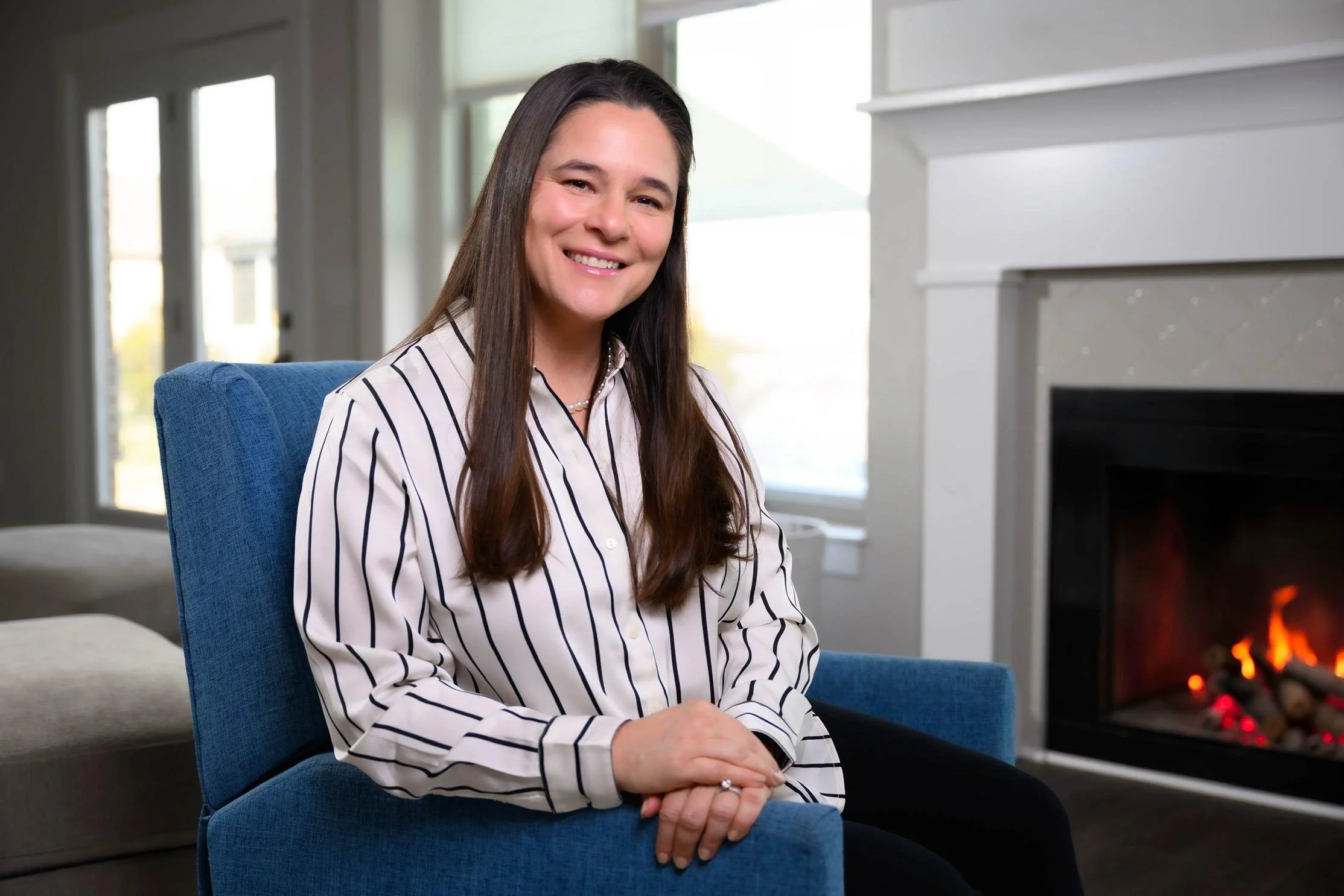 Photo of Sarah smiling in front of a fireplace