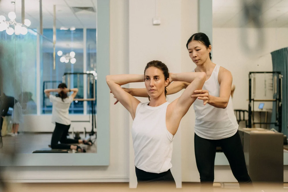 Instructor guiding scoliosis-focused Pilates