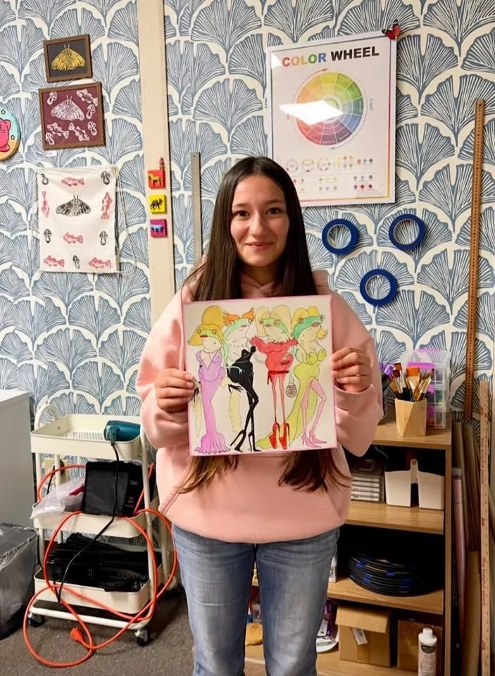 Local youth artist poses with art created during a DiRT & Glitter visual arts class with Jessica Cherry in Del Norte County, CA