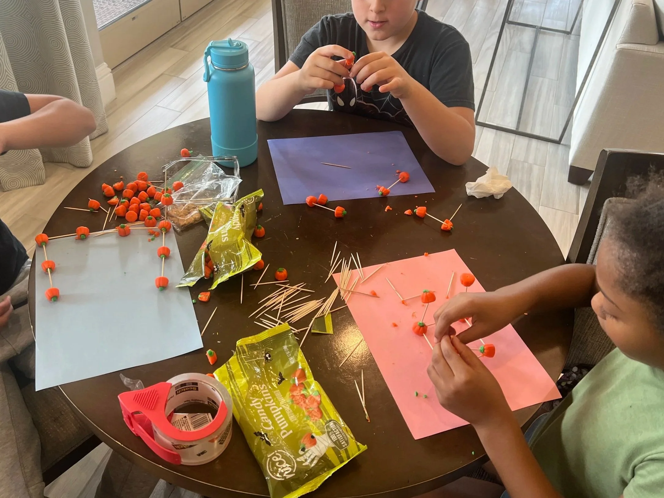 Kids building a structure using toothpicks and halloween pumpkins