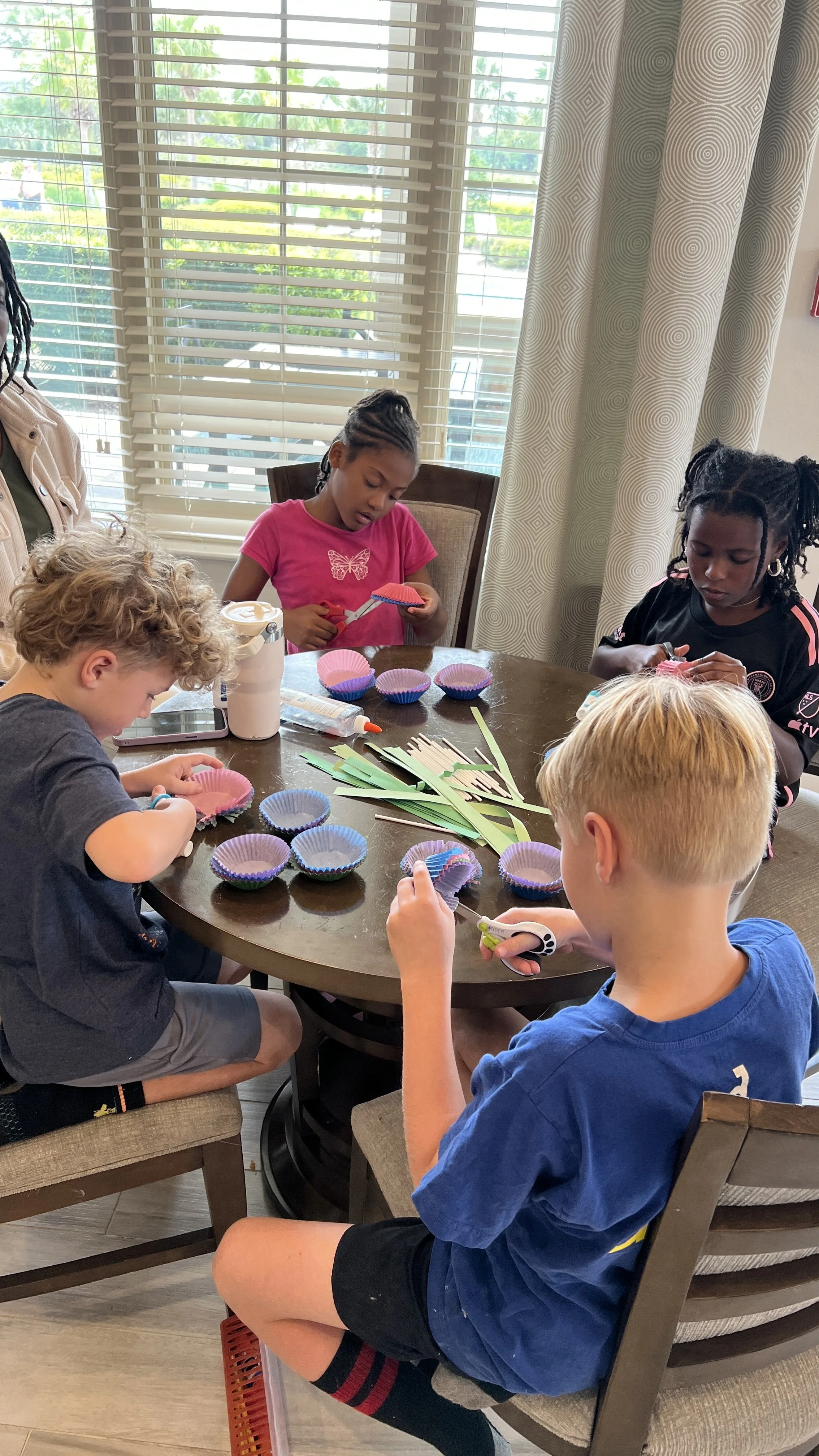 Child taking photo of flowers in a garden bed