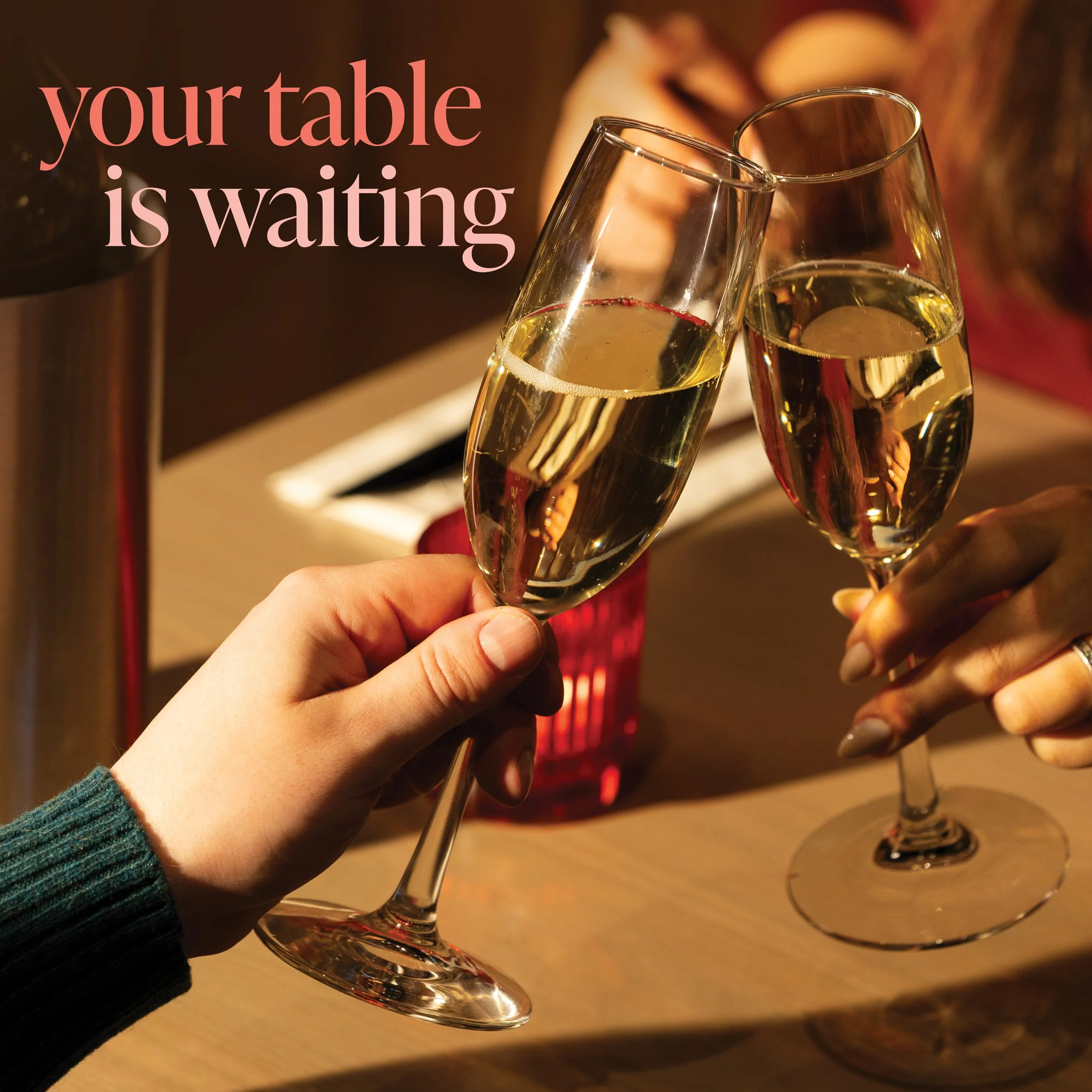 Two glasses of white champagne being clinked together in a toast.