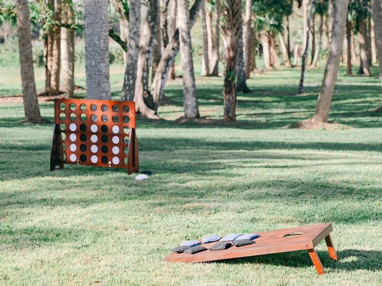 Guests enjoying outdoor yard games at Celebration Grove in Vero Beach, including Giant Connect Four, Giant Jenga, and cornhole, perfect for weddings, family events, and community celebrations.