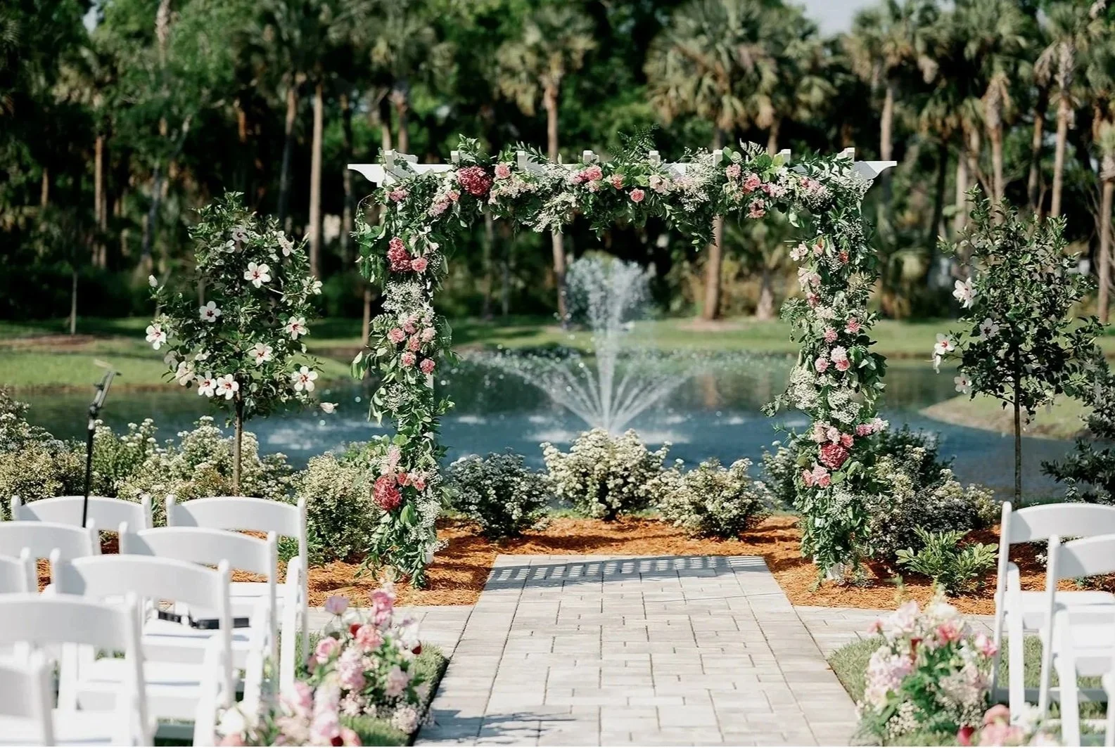 Lakeside arbor with fountain views at Celebration Grove, a Vero Beach wedding venue, offering elegant seating for outdoor ceremonies up to 200 guests.