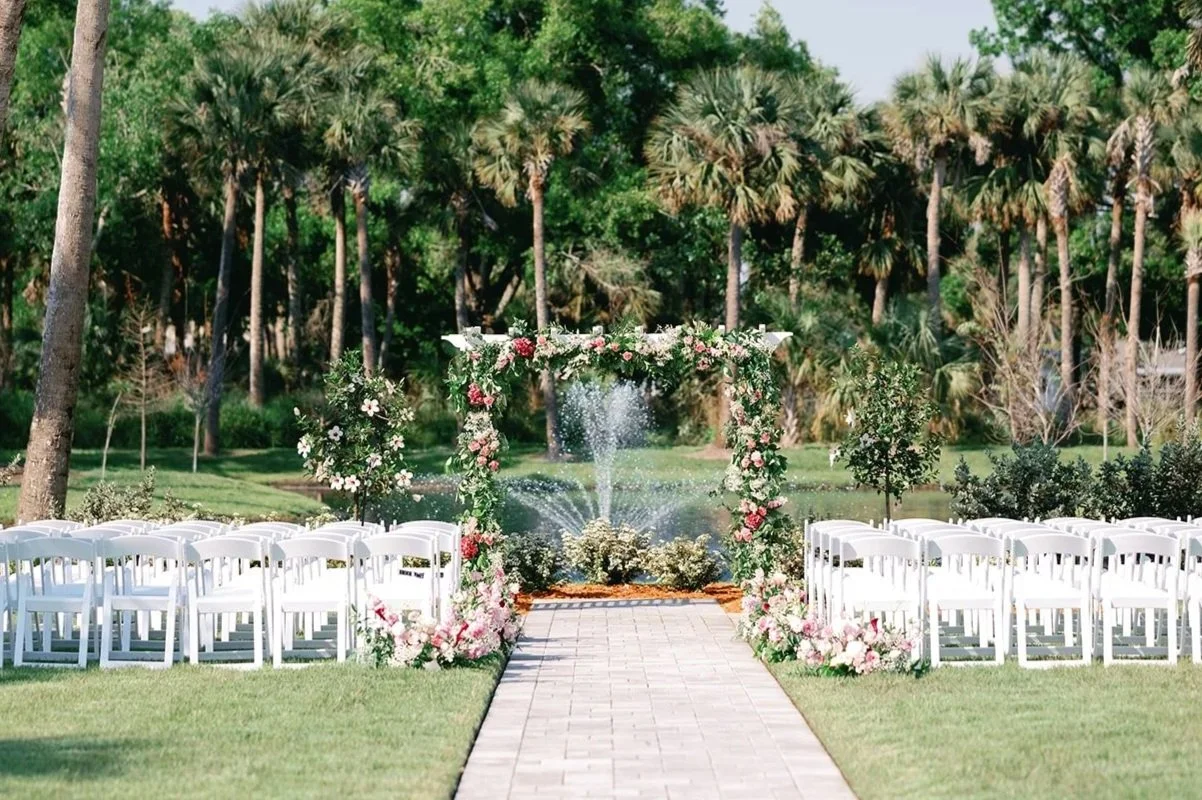 Lakeside arbor ceremony site at Celebration Grove in Vero Beach, Florida, nestled beneath ancient oaks beside a peaceful lake with a fountain — a sacred outdoor setting for weddings, vow renewals, and special celebrations.