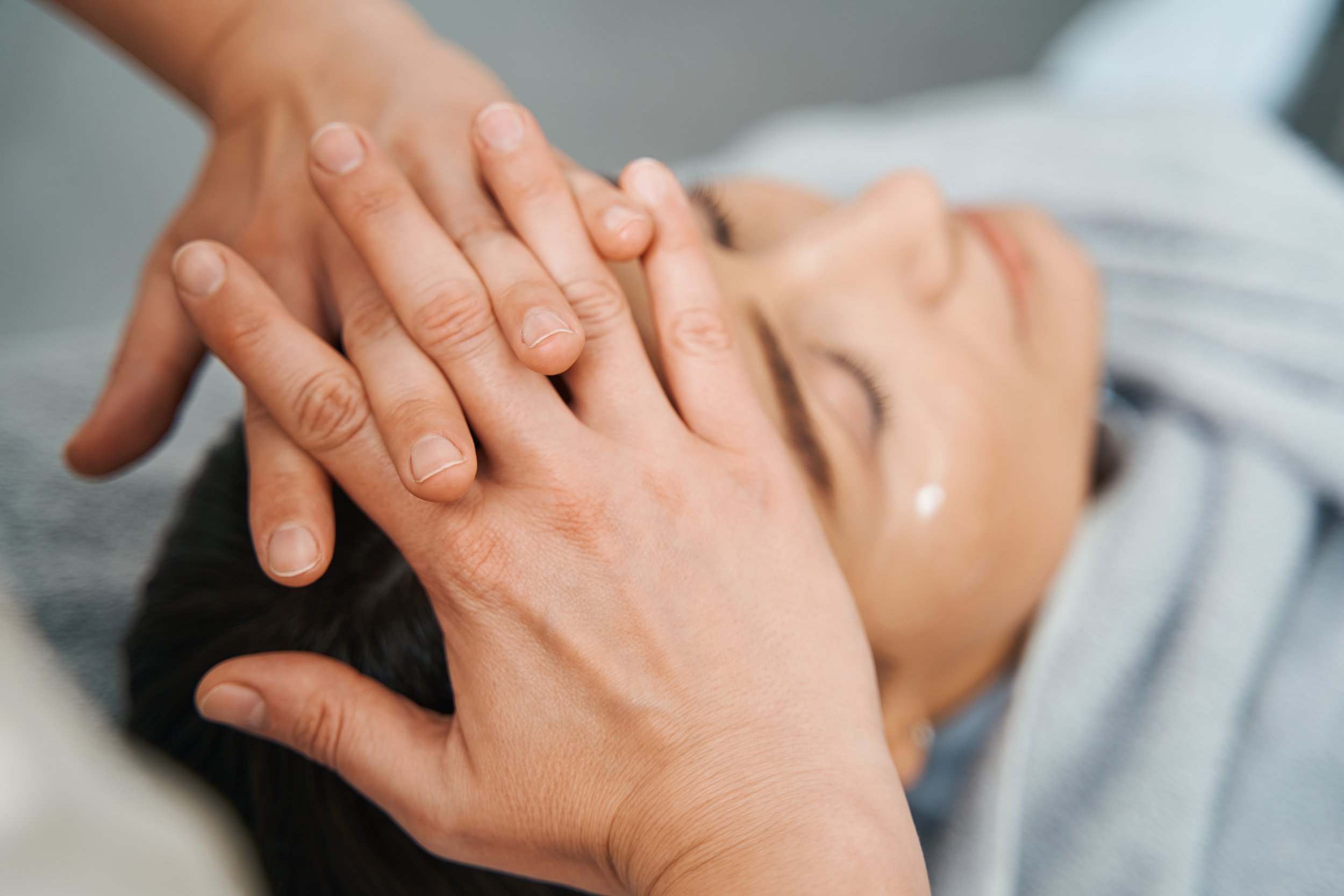 A woman receiving a head massage.