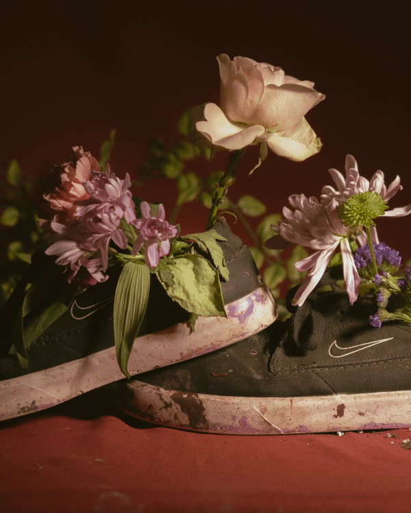 Paint-covered Nike sneakers with flowers growing out of them