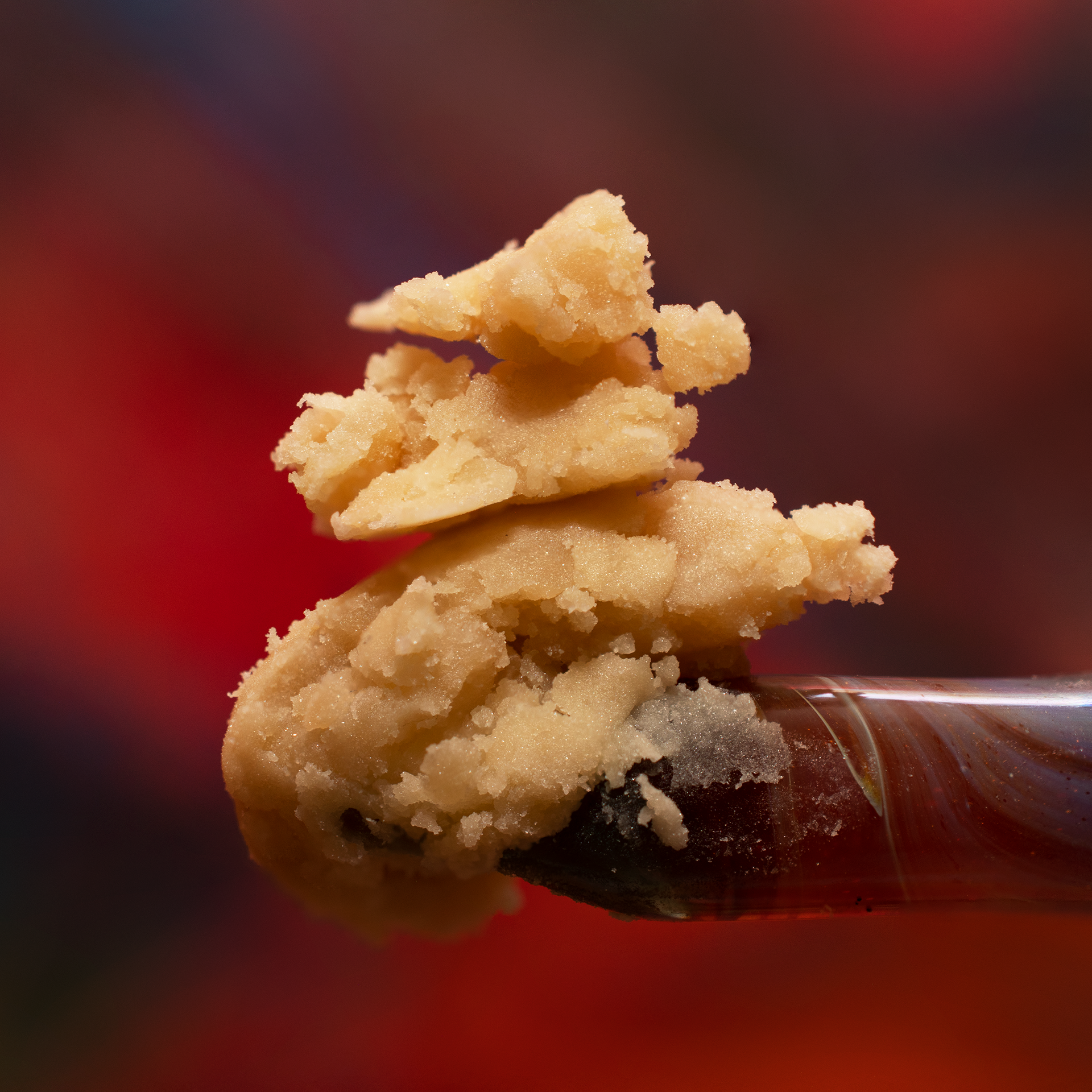 Close-up of broken pieces of cookie with chocolate chip crumbs, reflected on a shiny black surface.
