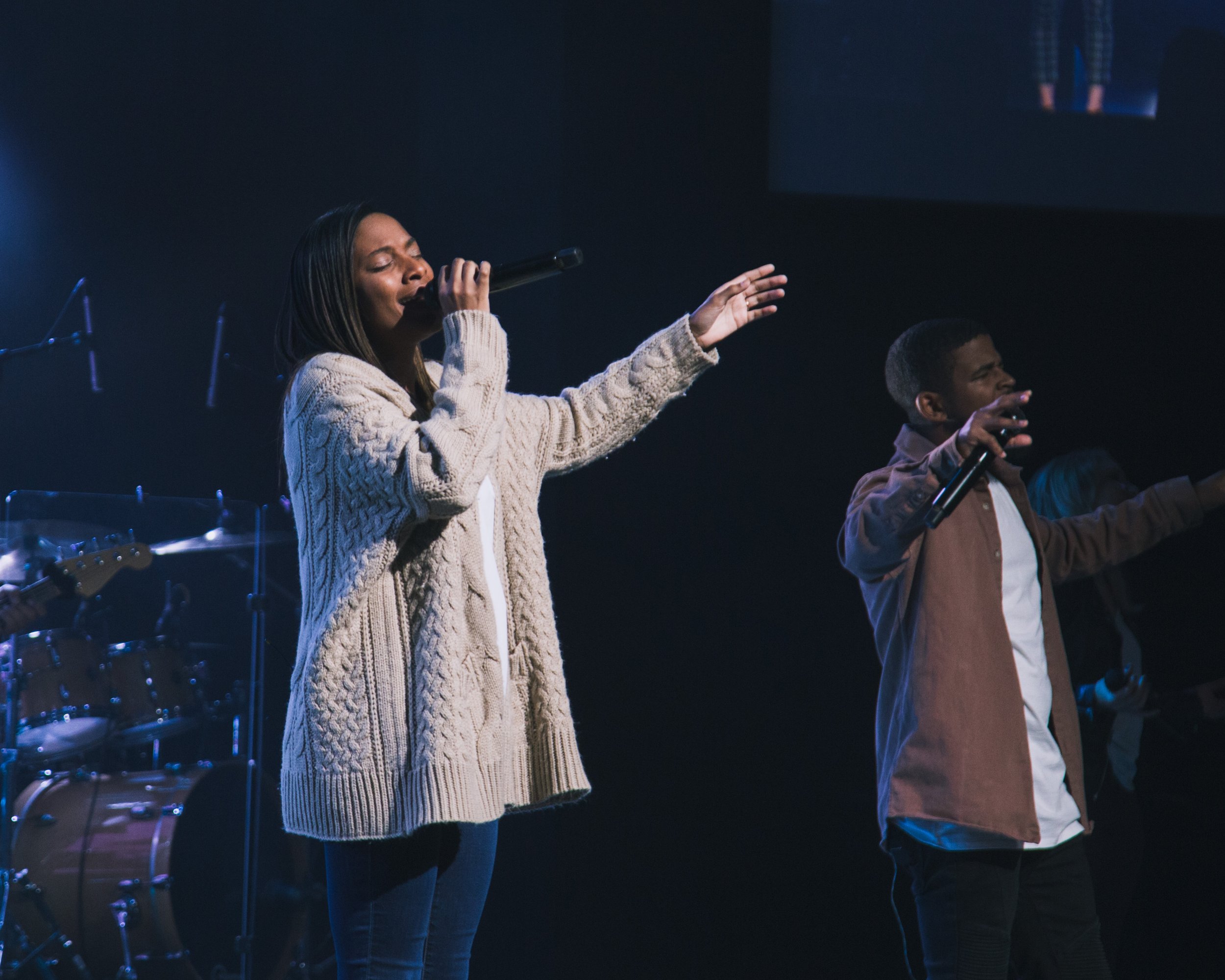  woman worshipping on stage at church 