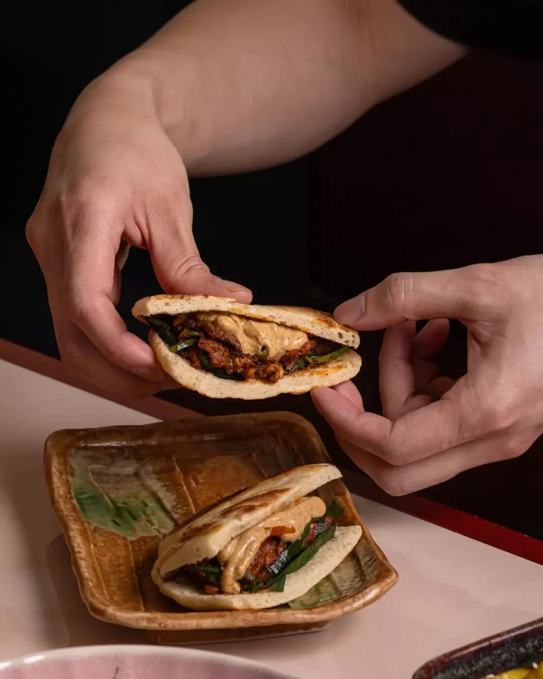 孜然羊肉夹馍: Lamb with cumin, served in a fried bun with red pepper, leek, and smoked yoghurt.