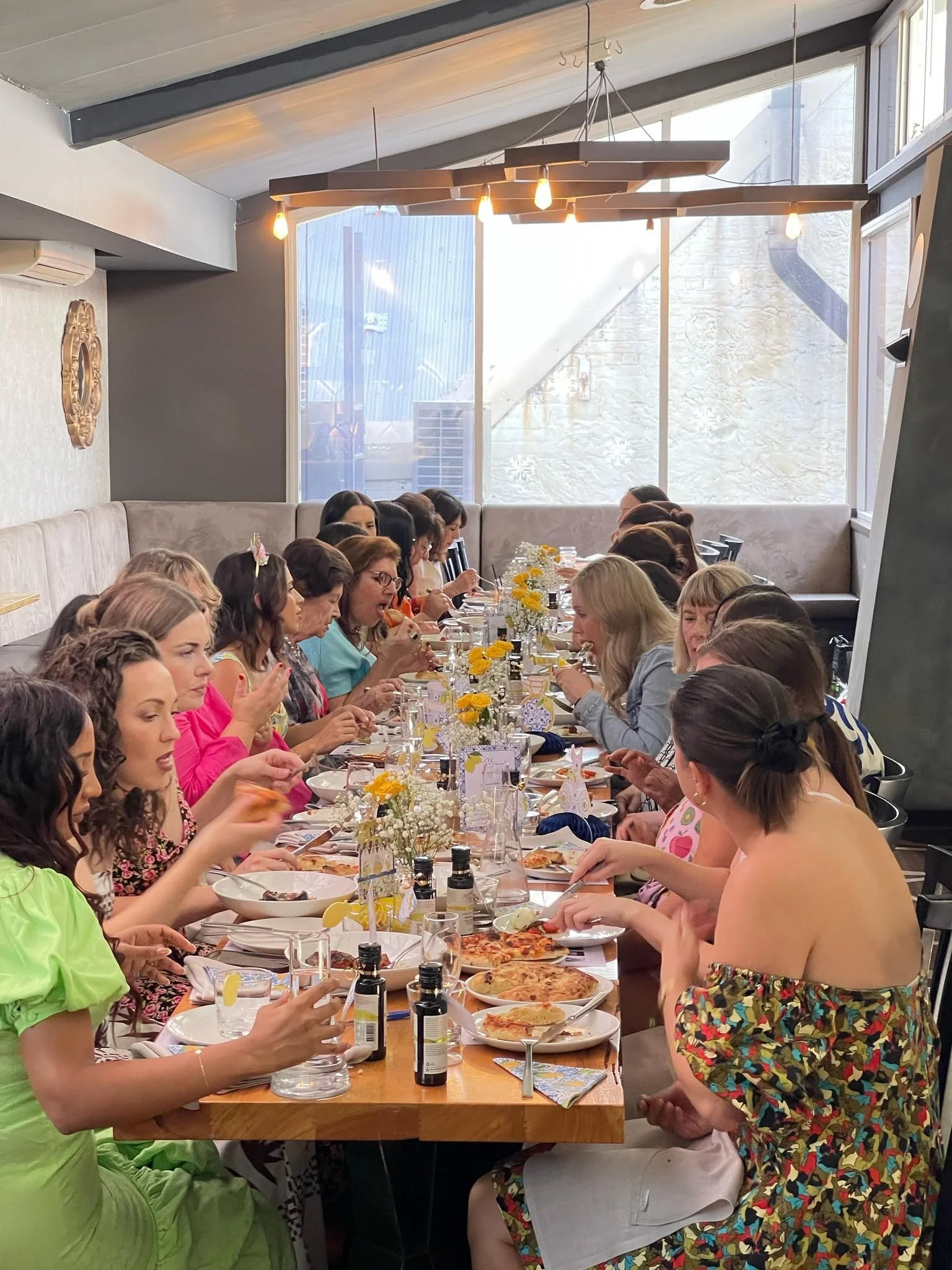Corporate event at La Sosta Fremantle featuring a group dining experience with guests enjoying Italian food together around a long table.